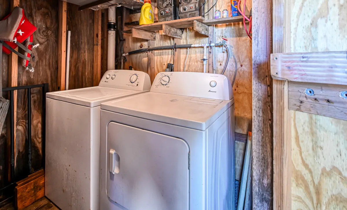 A practical laundry space with a modern washer and dryer, shelves neatly stocked with laundry supplies. The setting is clean and organized, reflecting the convenience of in-unit laundry facilities.